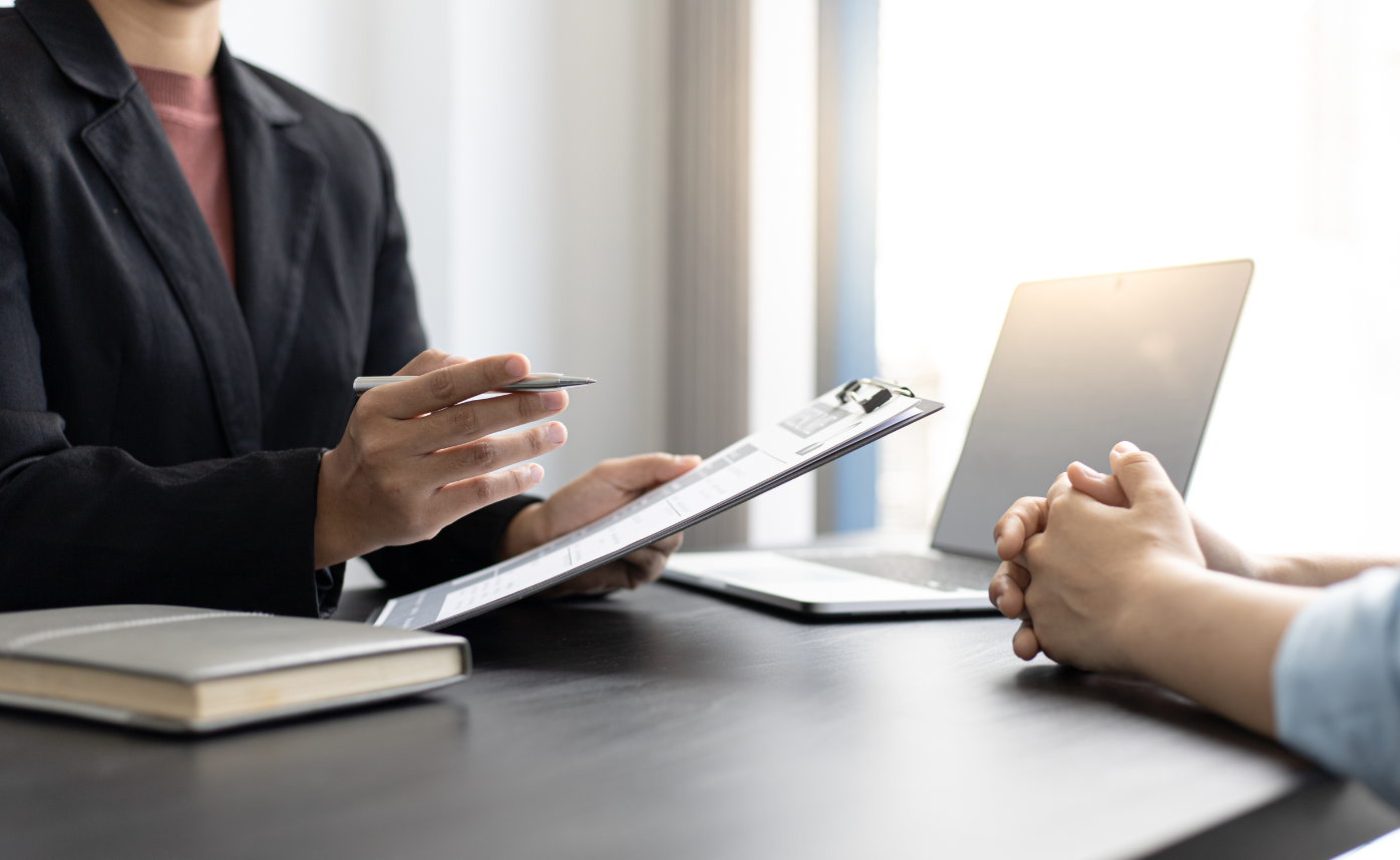 Two people speaking across a desk