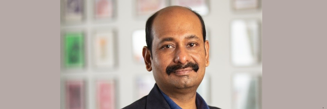 Professor Atanu Chaudhuri looking straight to camera against a blurred, light coloured background
