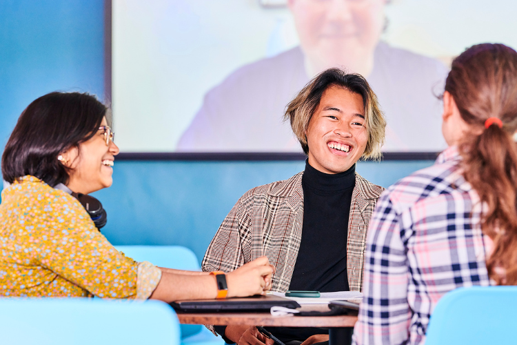Three students chatting at a seminar