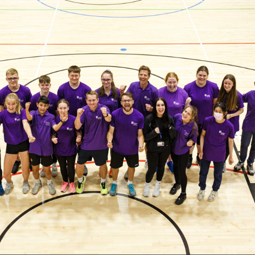 A large group of students stood in a sports court