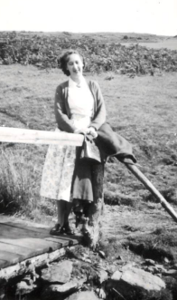 A black and white photo of of alumna Margaret Bloomfield walking in the countryside.