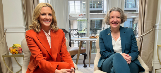 Gabby Logan in an orange suit seated next to our Vice-Chancellor in a green suit