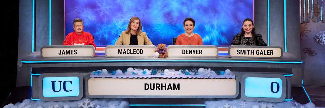 4 alumni sitting behind desks from BBC show University Challenge. From left Liz James, Tracey MacLeod, Carla Denyer and Sophia Smith Galer