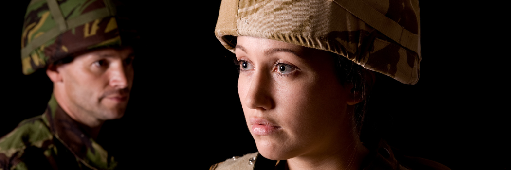 Image showing female solider in foreground and male solider in background within a dark setting