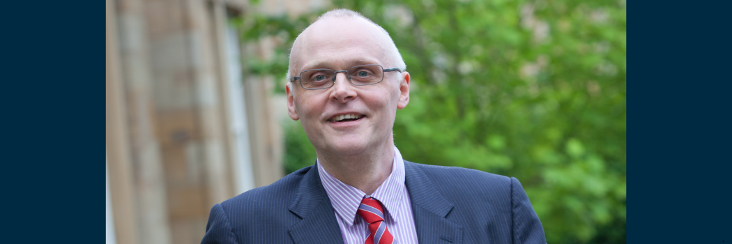 Professor Graham Towl looking to camera, taken outside with tree in background