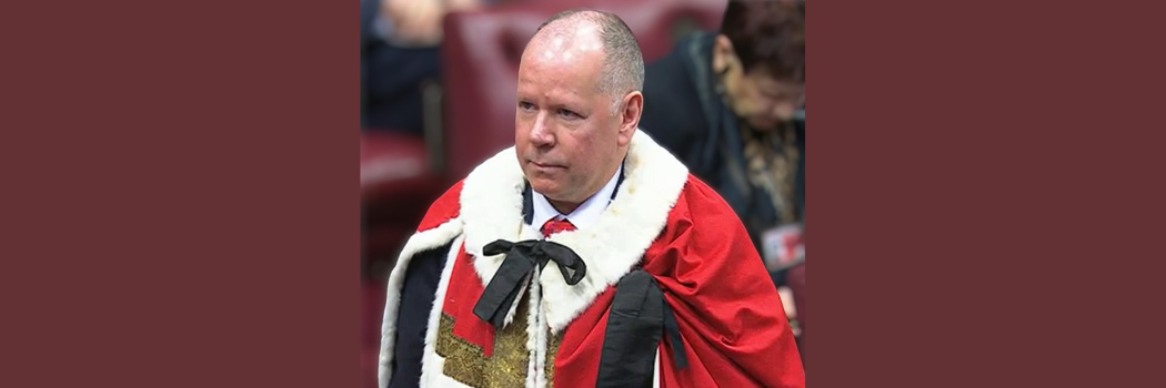 Male in red House of Lord robes, looking off camera