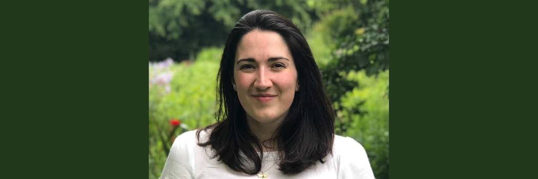 Woman facing camera, smiling. Head and shoulders visible
