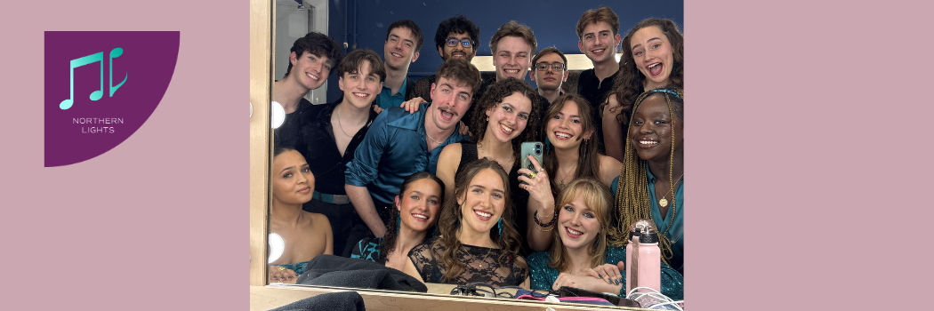 A group of students taking a selfie in a backstage mirror
