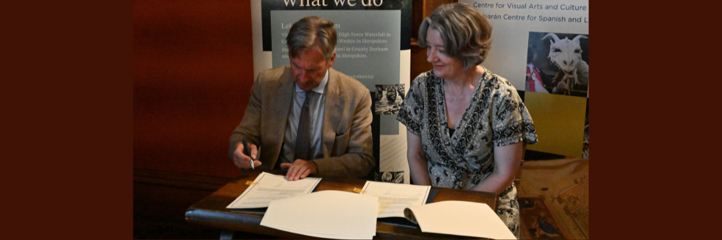 Lord Barnard and Karen O'Brien sitting at a table signing the MoU document