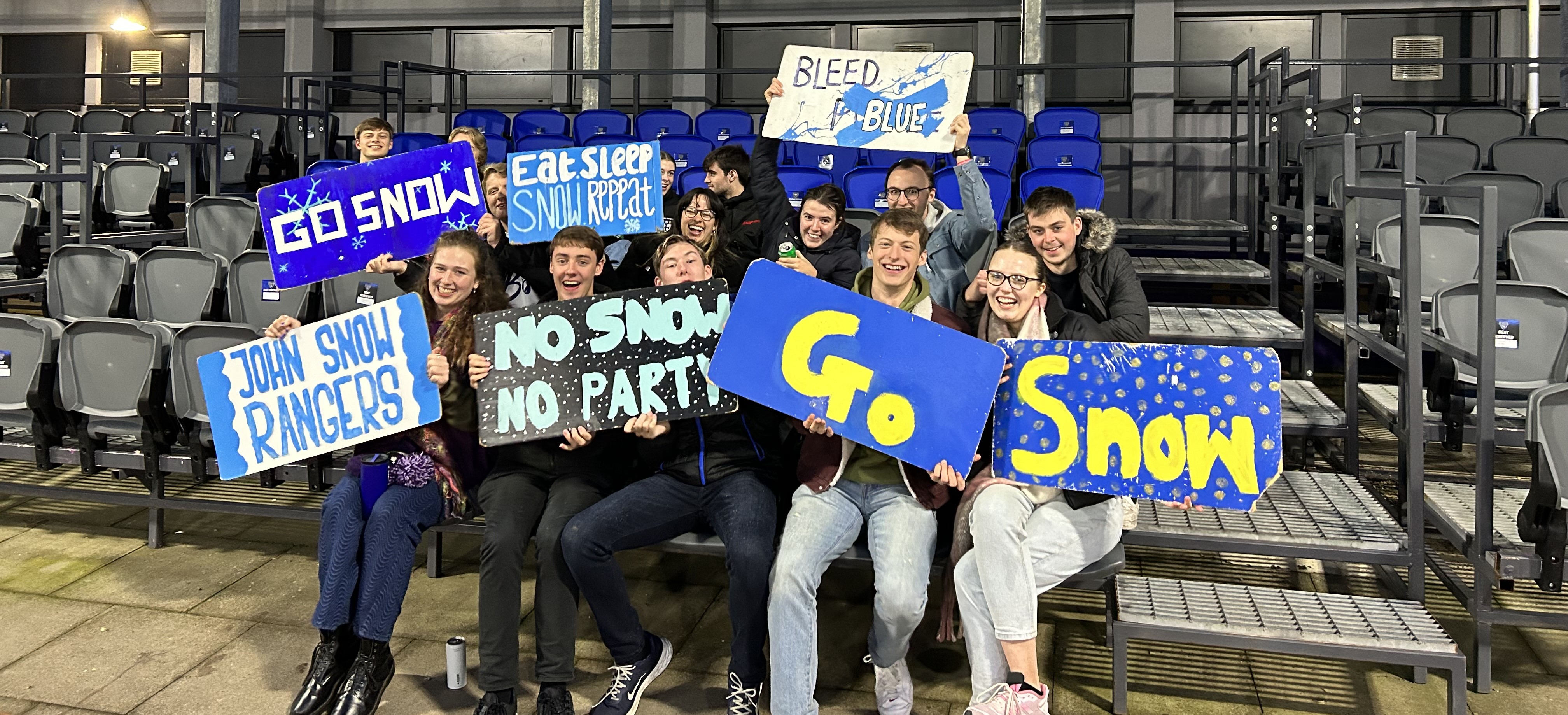 Group of students with John Snow signs at an event