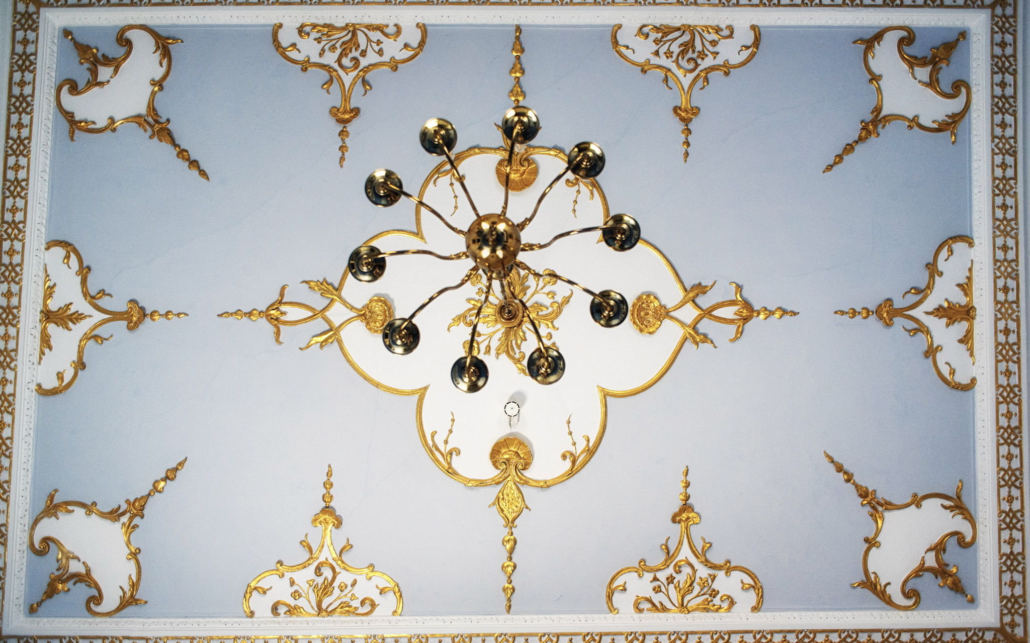 Golden decorative ceiling and chandelier in St Johns College