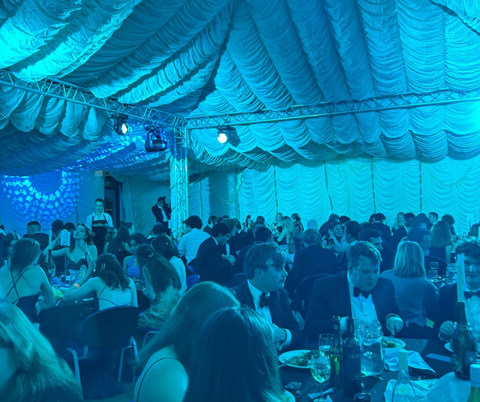 people in formal dress at at a table in a blue lit room