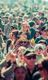crowd of people moving towards the camera on a sunny day