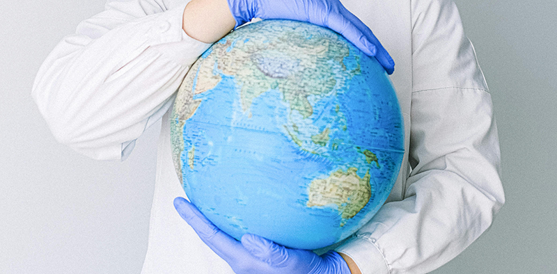 Hands with medical gloves holding a globe