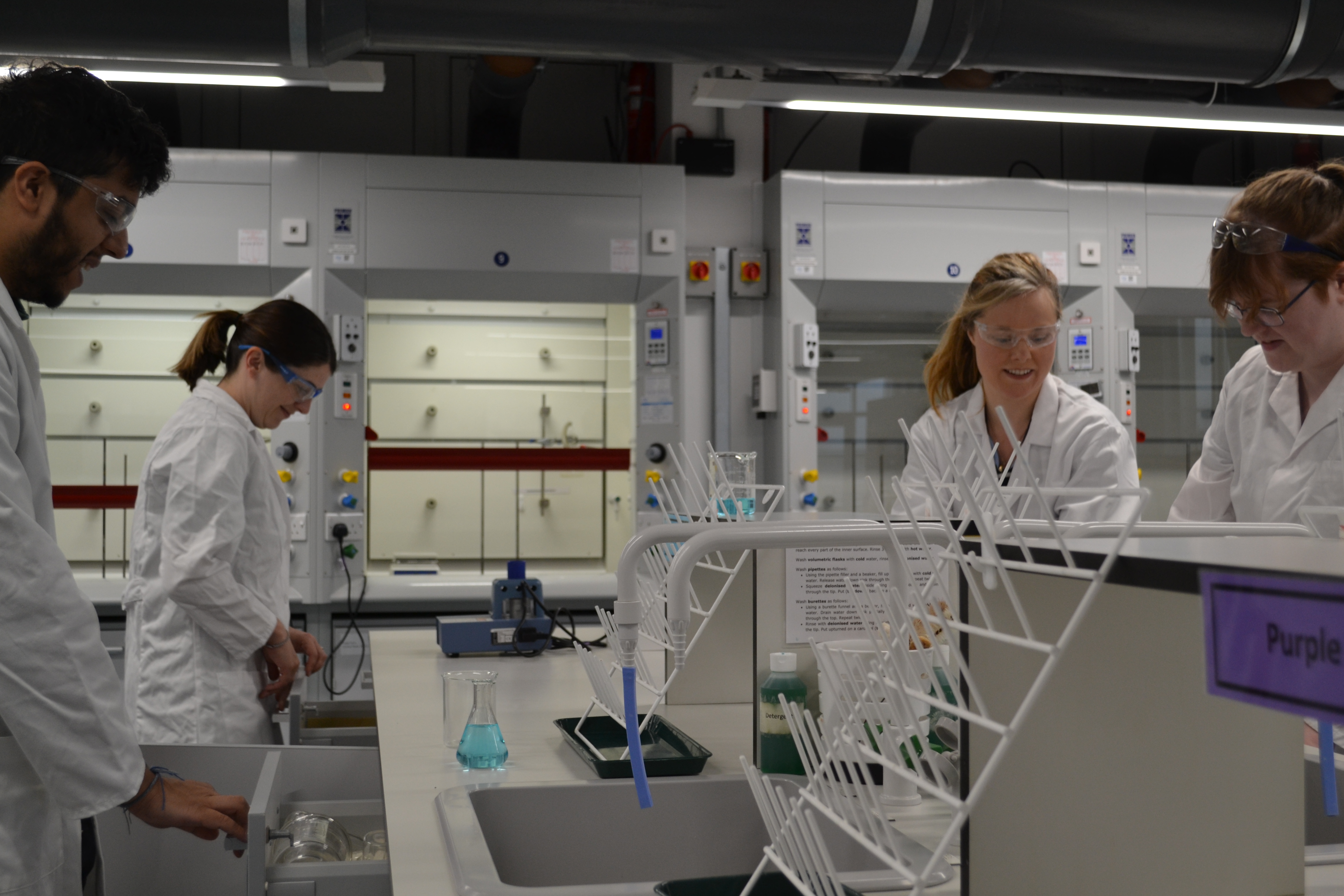 Four students undertake an experiment in our Chemistry lab.