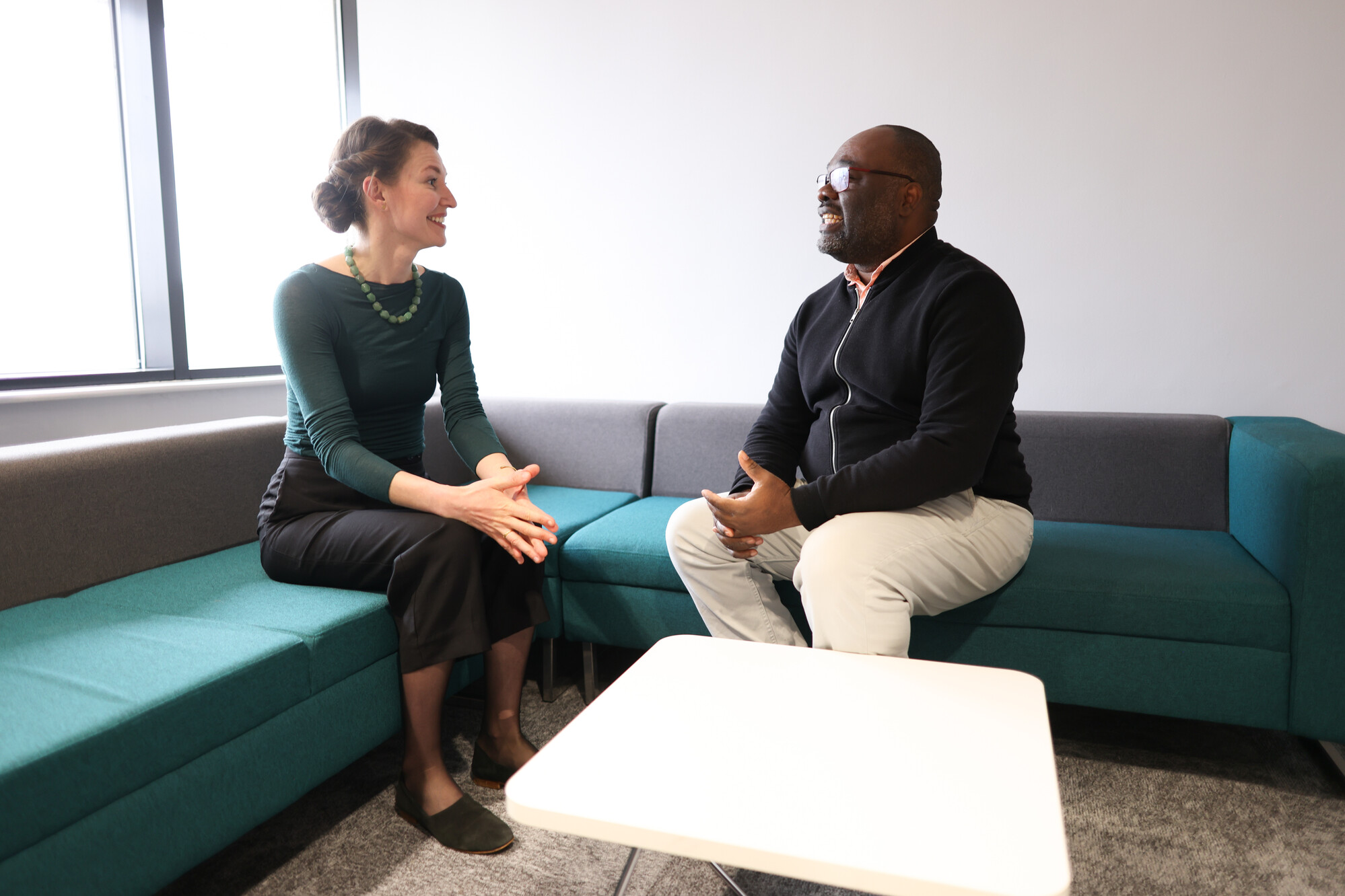 Two colleagues sit together talking