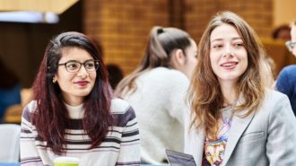 Two female students sitting side by side.