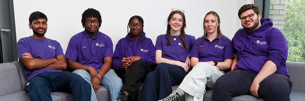 6 student ambassadors sit, smiling at the camera.