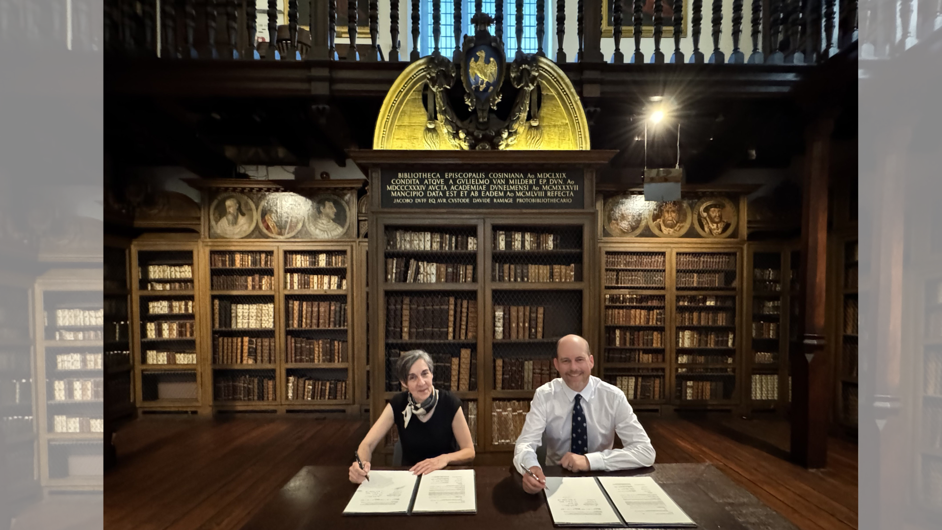 Professor Janet Stewart, Executive Dean of Durham University’s Faculty of Arts and Humanities, alongside Dr Jonathan Deane Parker, Associate Professor and Chair of the Department of Religion and Philosophy (Berry College) in Cosin's Library sign agreement.