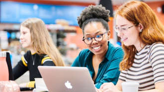 A picture of two female students looking at a laptop.