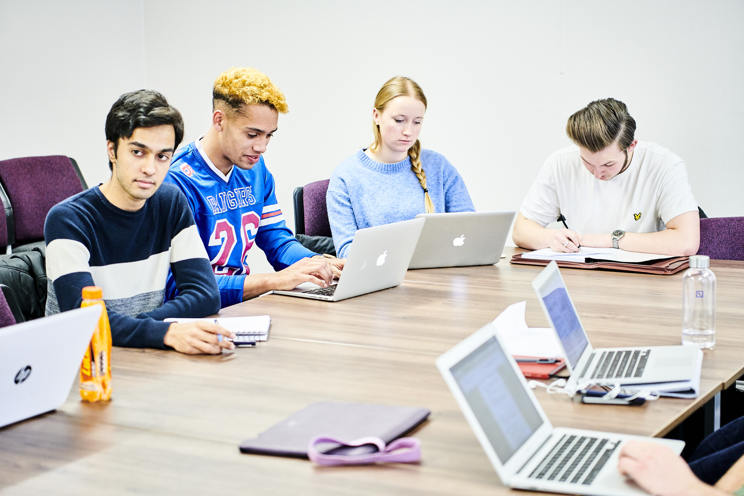 Students sitting round a table with laptops