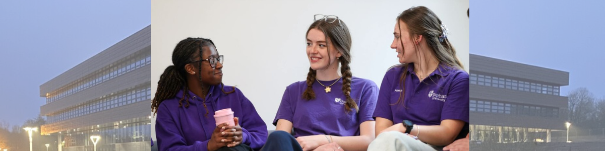A group of three female students sitting together. Background shows Department of Mathematical Sciences building.