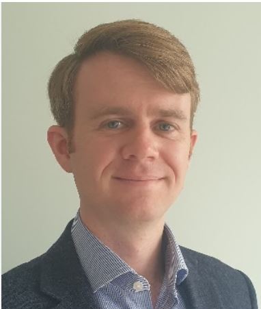 Man with light coloured hair wearing a blue striped collared shirt
