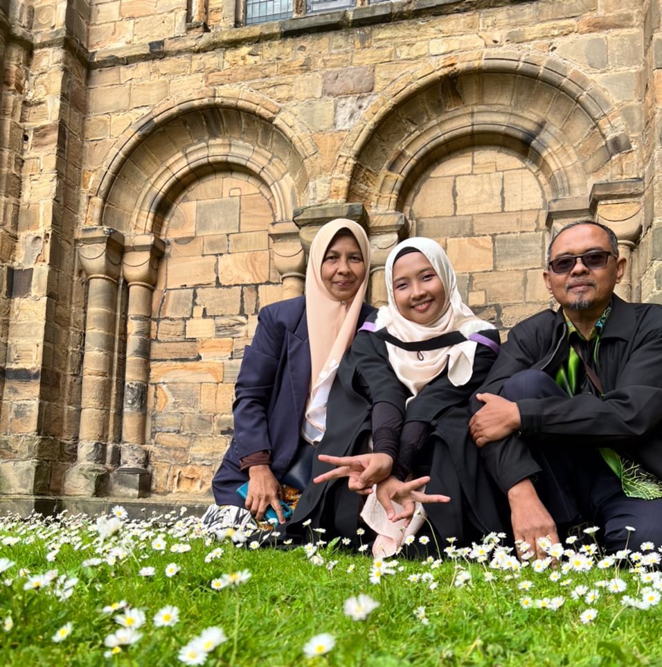 Student with parents outside Durham Cathedral celebrating graduation