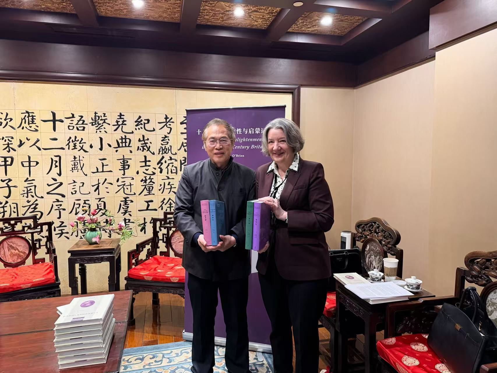 Vice-Chancellor Karen O'Brien being presented the books by Huang Bikang of Peking University.