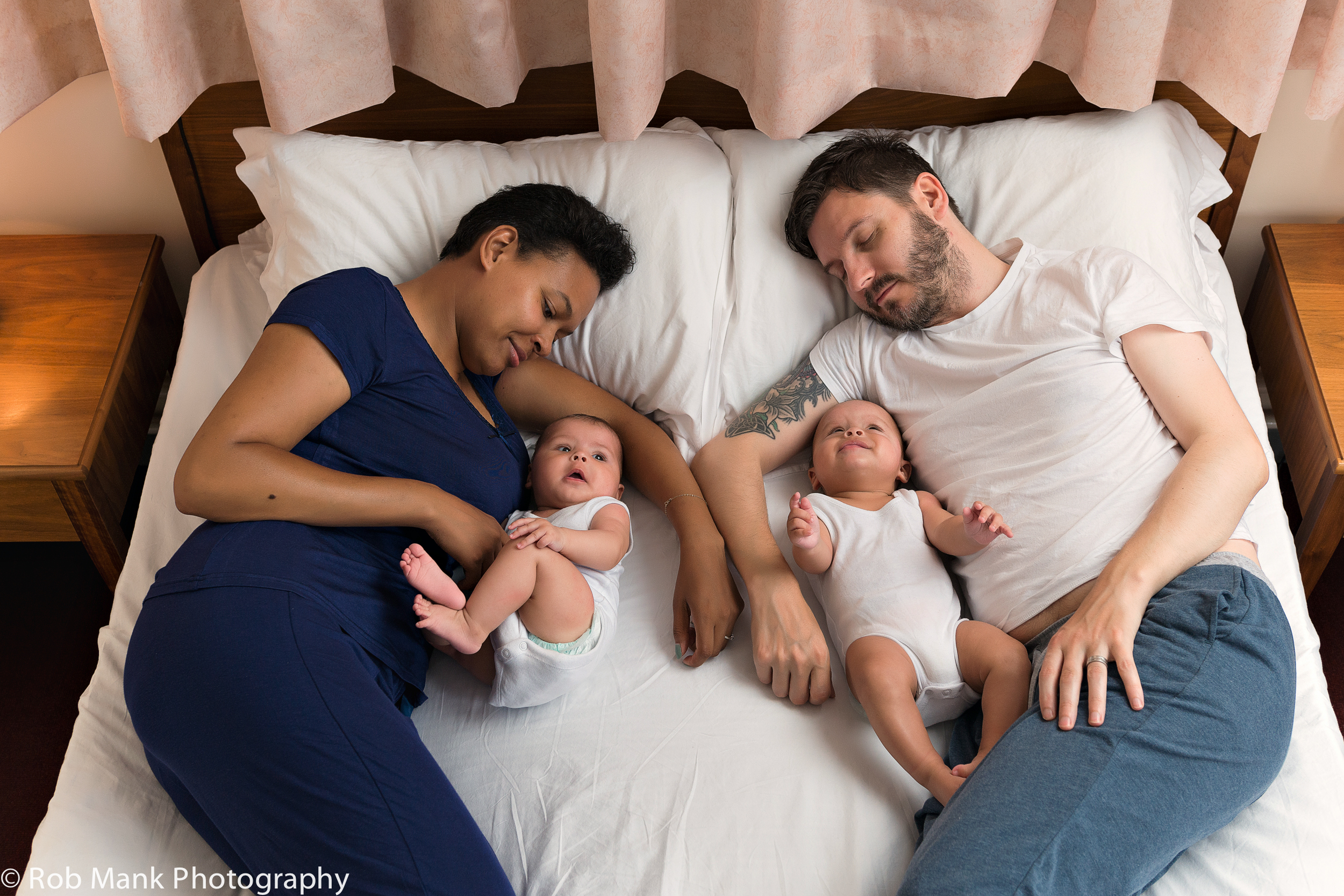 Parents lying next to babies in bed
