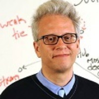 Headshot of Academic standing in front of a whiteboard