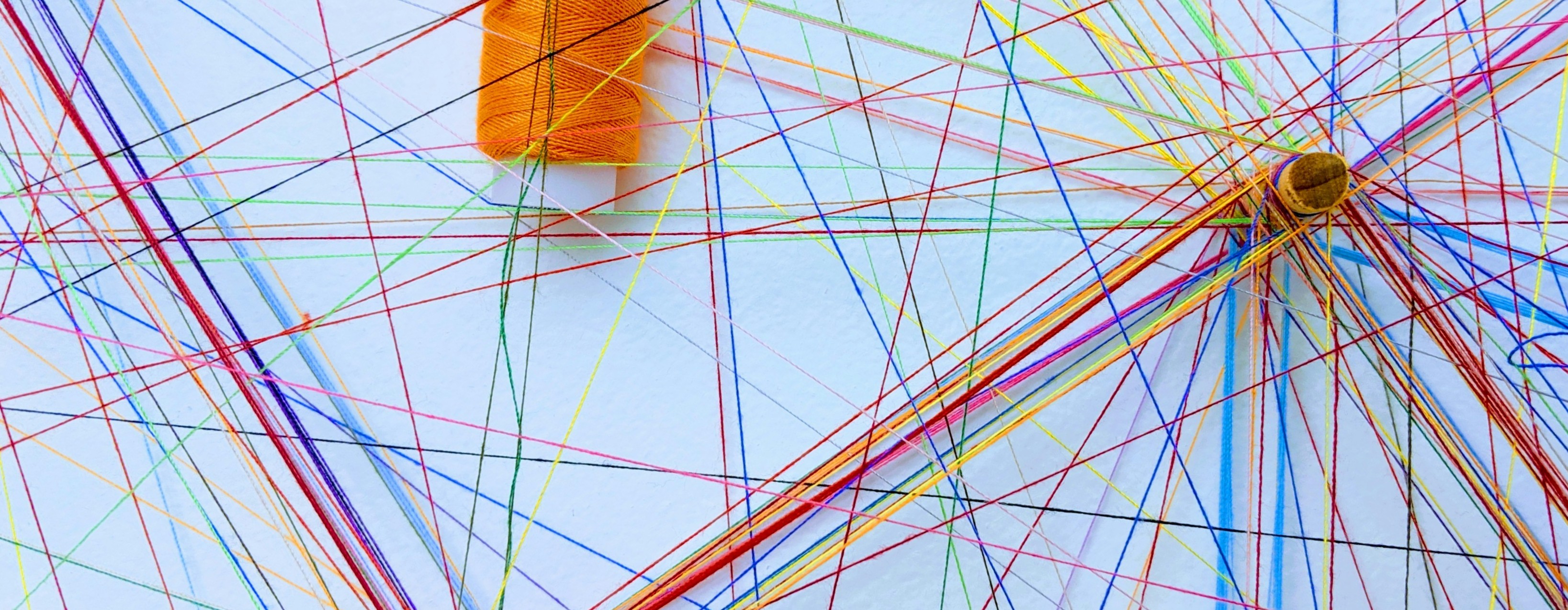 colourful threads on a white background, crossing and connecting.