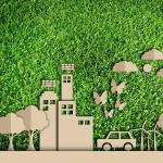 Cardboard cut out town and car on a green background