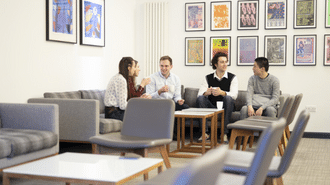 A group of students sat on a settee talking