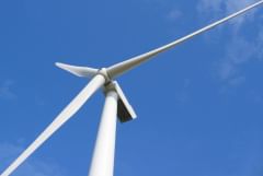 Single wind turbine against a blue sky.