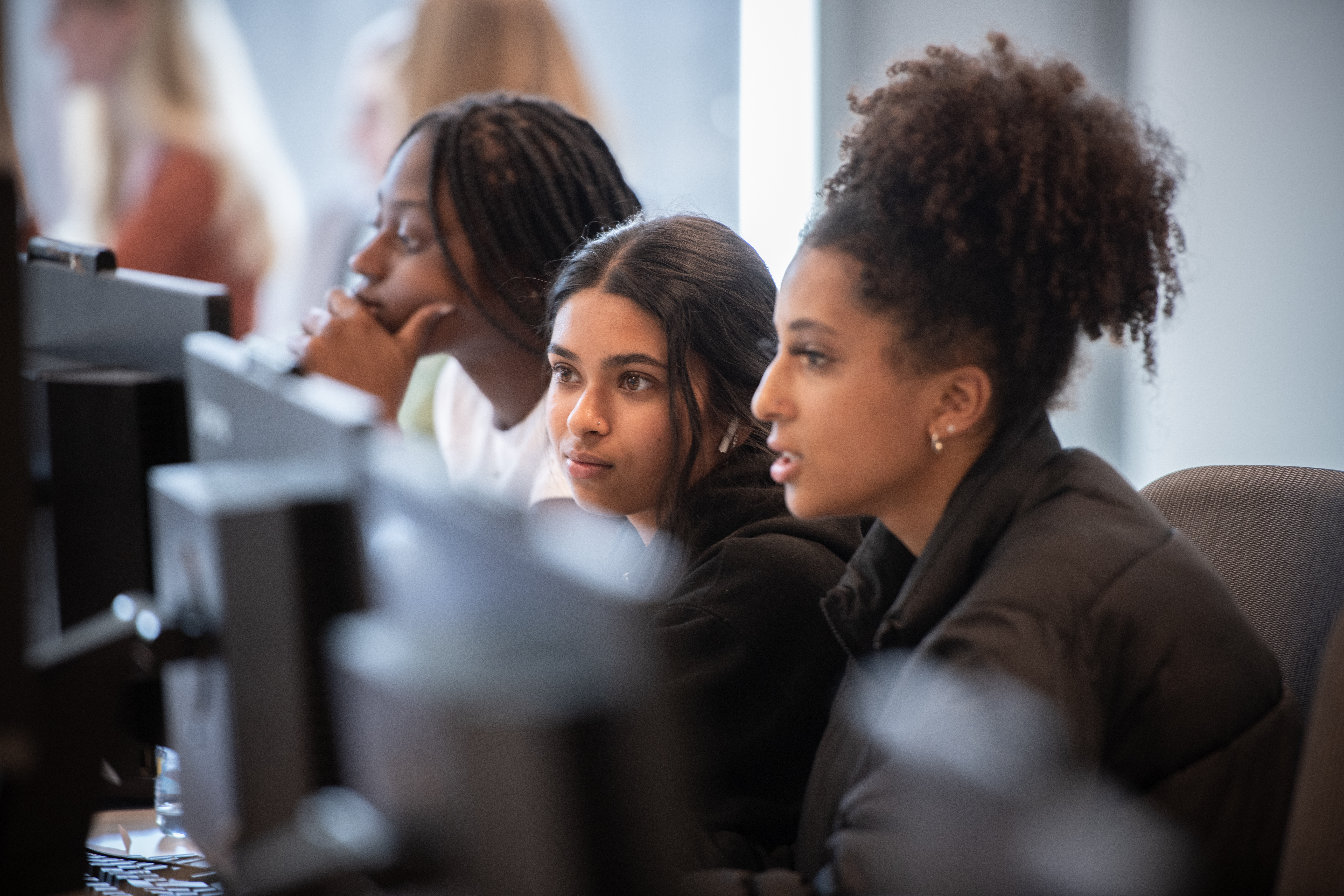 Three students looking at computers