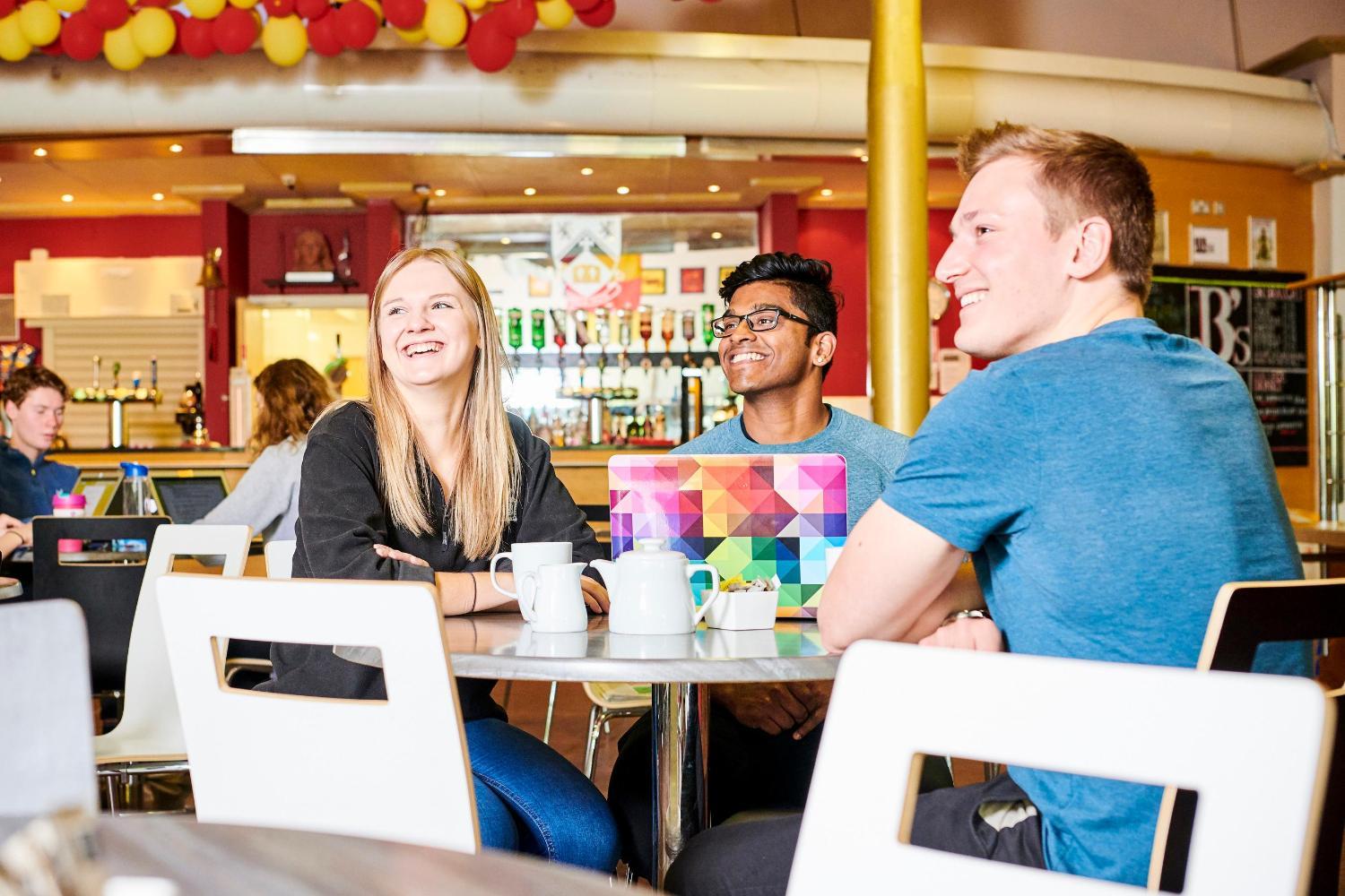 Students on laptop with cups of tea in Josephine Butler College café